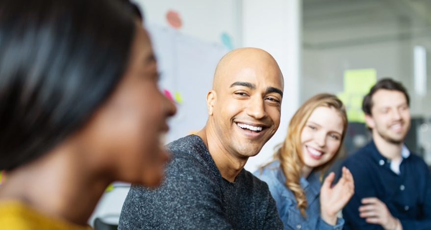 A group of individuals smile at each other